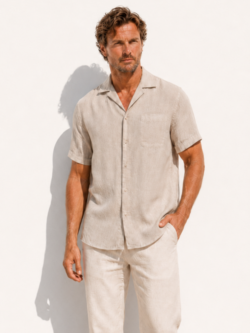 Man wearing a beige linen shirt and pants against a white background
